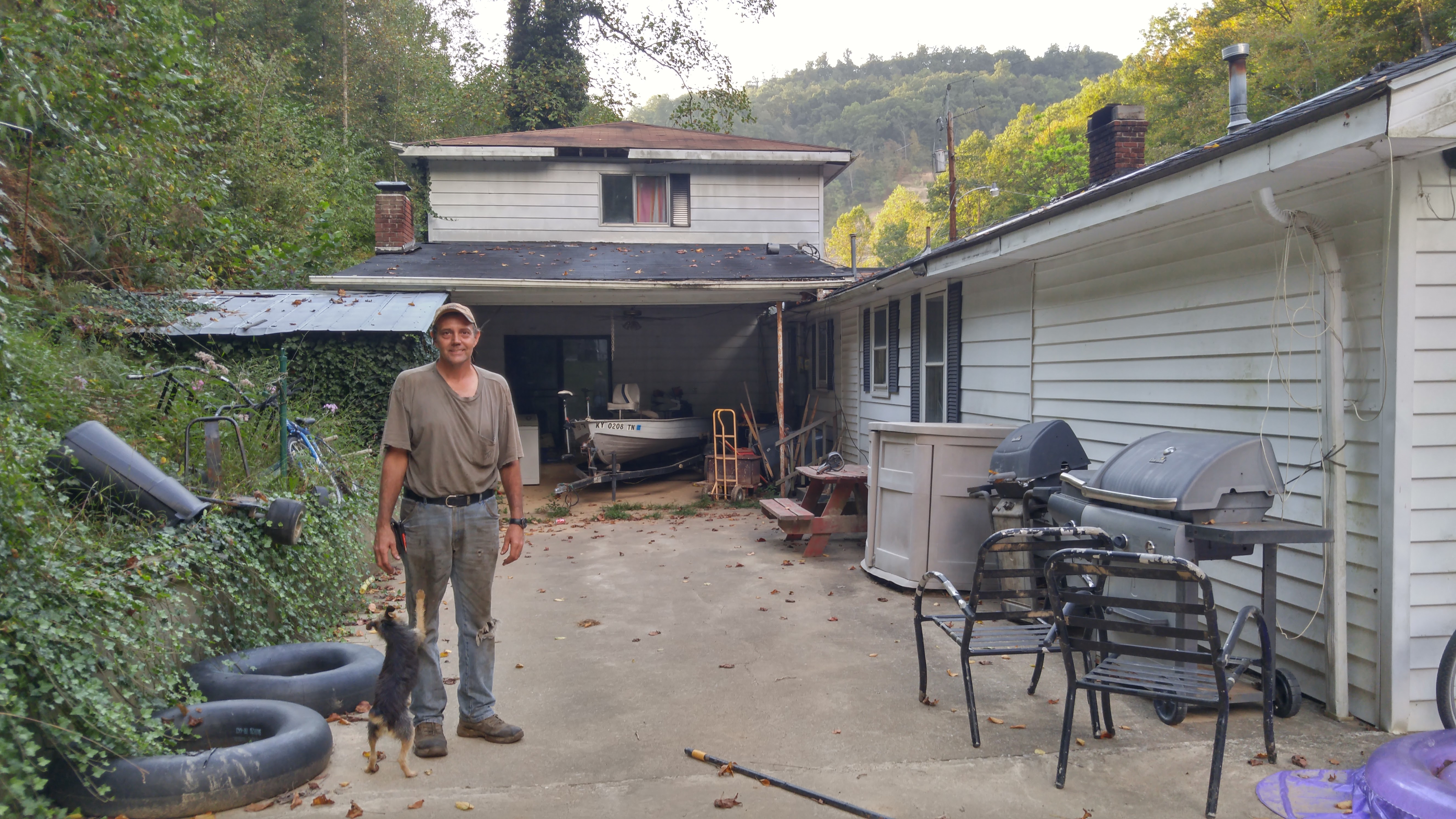 Elvis Thacker stands outside his ruined home on the back patio that was covered by more than a foot and a half of mud.