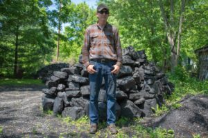 David Boyd stands in front of a pile of coal he sells to the general public for things like heating or blacksmithing.