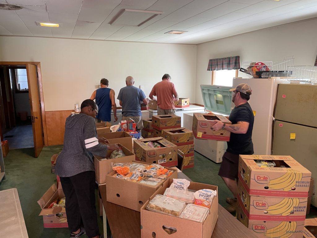 Volunteers at the Ken-Tenn Food Bank unpack boxes of donated food.
