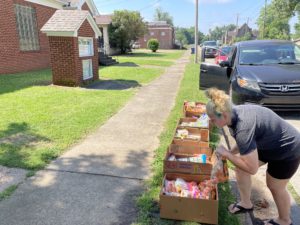 Latoya Maurer reaches down to look at some of the produce at the Ken-Tenn Food Bank.