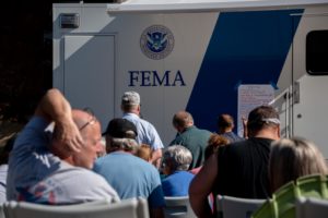 A line waits outside a FEMA truck to apply for aid.