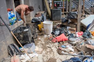 A man living in an apartment in Darfork empties out his mud-covered possessions and tries to clean off what is salvageable.